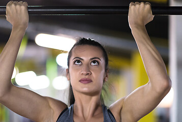 Image showing woman doing pull ups on the horizontal bar