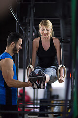 Image showing woman working out with personal trainer on gymnastic rings