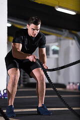 Image showing athlete man doing battle ropes cross fitness exercise