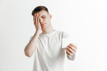 Image showing Young boy with a surprised unhappy failure expression bet slip on studio background.