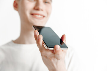 Image showing Indoor portrait of attractive young man holding smartphone