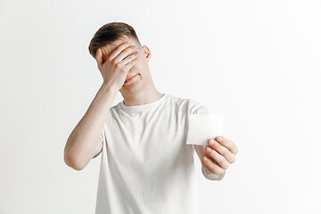 Image showing Young boy with a surprised unhappy failure expression bet slip on studio background.