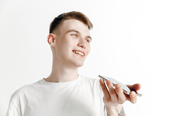 Image showing Indoor portrait of attractive young man holding smartphone