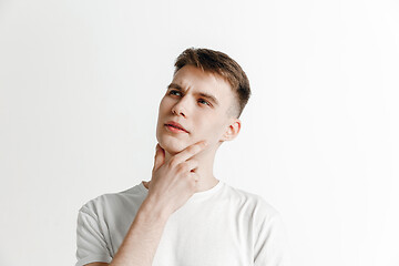 Image showing Young dreaming man isolated on white background looking at something