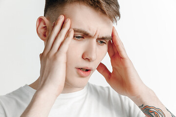 Image showing Man having headache. Isolated over gray background.