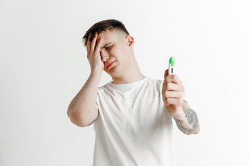 Image showing Upset man looking in pregnancy test. Frustrated model