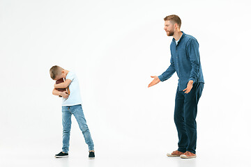 Image showing Angry father scolding his son in living room at home