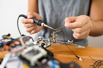 Image showing Man welding the wire for assemble of drone