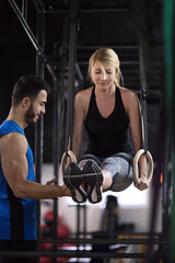 Image showing woman working out with personal trainer on gymnastic rings