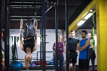 Image showing woman working out with personal trainer on gymnastic rings