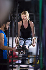 Image showing woman working out with personal trainer on gymnastic rings