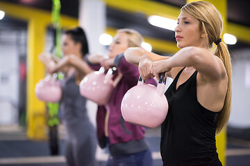 Image showing athletes doing exercises with kettlebells