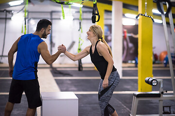 Image showing woman working out with personal trainer jumping on fit box