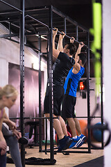 Image showing young athletes doing pull ups on the horizontal bar