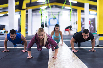 Image showing young healthy people doing pushups