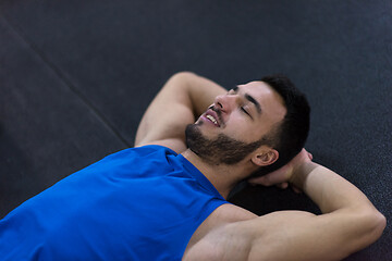 Image showing young athlete man lying on the floor and relaxing