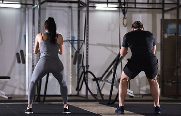 Image showing sports couple doing battle ropes cross fitness exercise