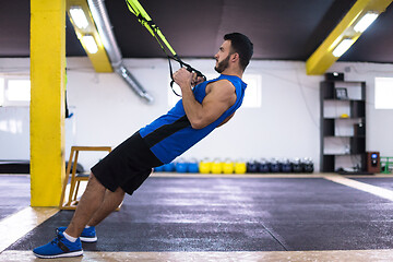 Image showing man working out pull ups with gymnastic rings