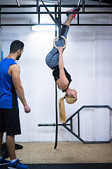 Image showing woman working out with personal trainer on gymnastic rings