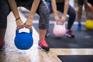 Image showing athletes doing exercises with kettlebells