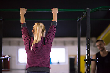 Image showing woman doing pull ups on the horizontal bar