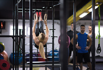 Image showing woman working out with personal trainer on gymnastic rings