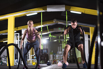 Image showing sports couple doing battle ropes cross fitness exercise