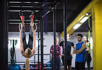 Image showing woman working out with personal trainer on gymnastic rings