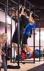 Image showing young athletes doing pull ups on the horizontal bar