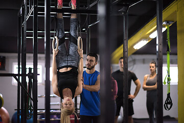 Image showing woman working out with personal trainer on gymnastic rings