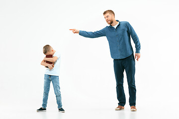 Image showing Angry father scolding his son in living room at home