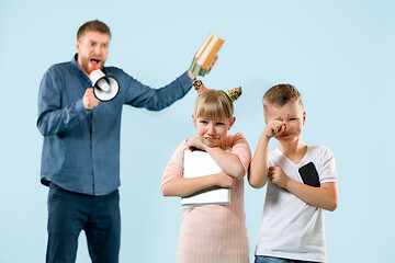 Image showing Angry father scolding his son in living room at home