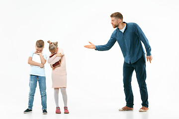 Image showing Angry father scolding his son in living room at home