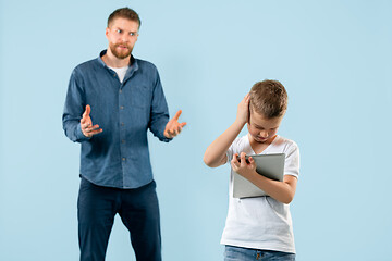 Image showing Angry father scolding his son in living room at home