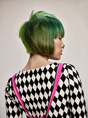 Image showing Close-up indoor portrait of lovely girl with colorful hair. Studio shot of graceful young woman with short haircut