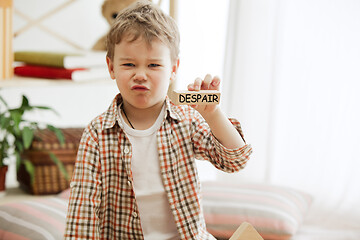Image showing Wooden cubes with word despair in hands of little boy
