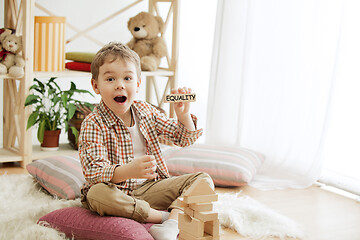 Image showing Wooden cubes with word EQUALITY in hands of little boy