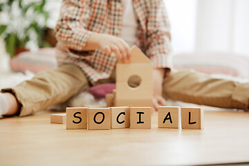 Image showing Wooden cubes with word SOCIAL in hands of little boy