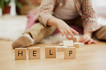 Image showing Wooden cubes with word HELP in hands of little boy