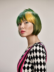 Image showing Close-up indoor portrait of lovely girl with colorful hair. Studio shot of graceful young woman with short haircut