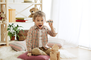 Image showing Wooden cubes with word PEOPLE in hands of little boy