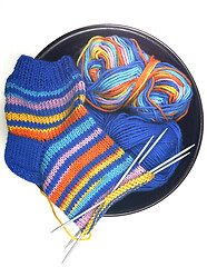 Image showing wool knitted sock, yarn and knitting needles on white
