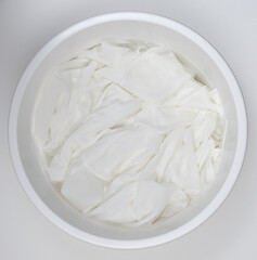 Image showing washing white linen in a white plastic bowl 