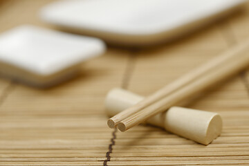 Image showing japanese chopsticks on stand and sushi dishes