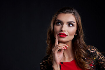 Image showing Closeup woman in red dress and red lips makeup looking away