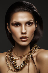 Image showing beautiful girl with many golden and bronze chains