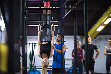 Image showing woman working out with personal trainer on gymnastic rings