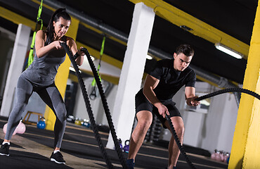 Image showing sports couple doing battle ropes cross fitness exercise