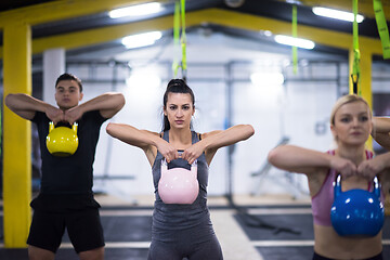 Image showing athletes doing exercises with kettlebells