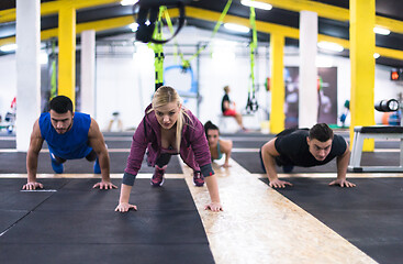 Image showing young healthy people doing pushups